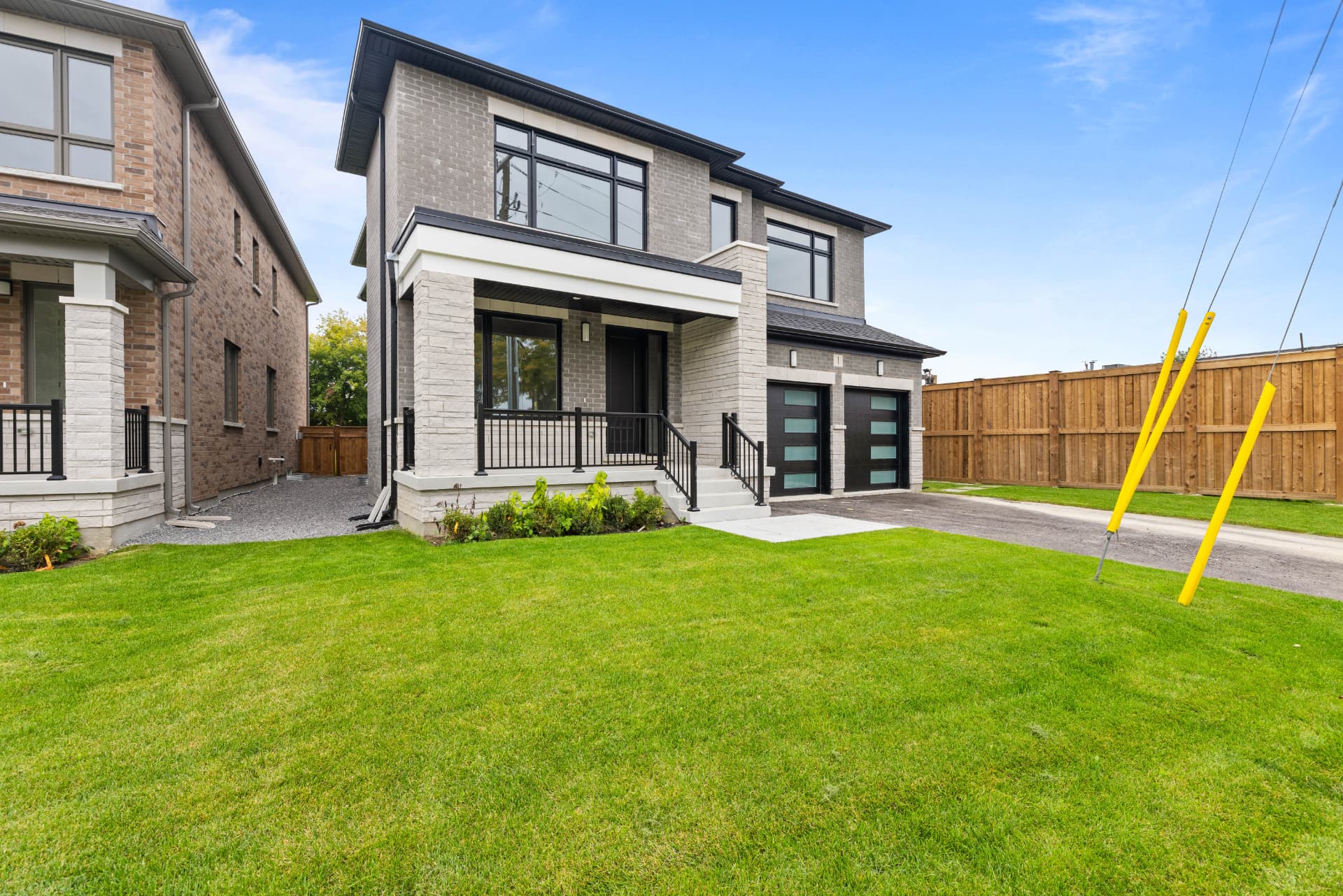 Front elevation from the lawn with covered porch and paved driveway