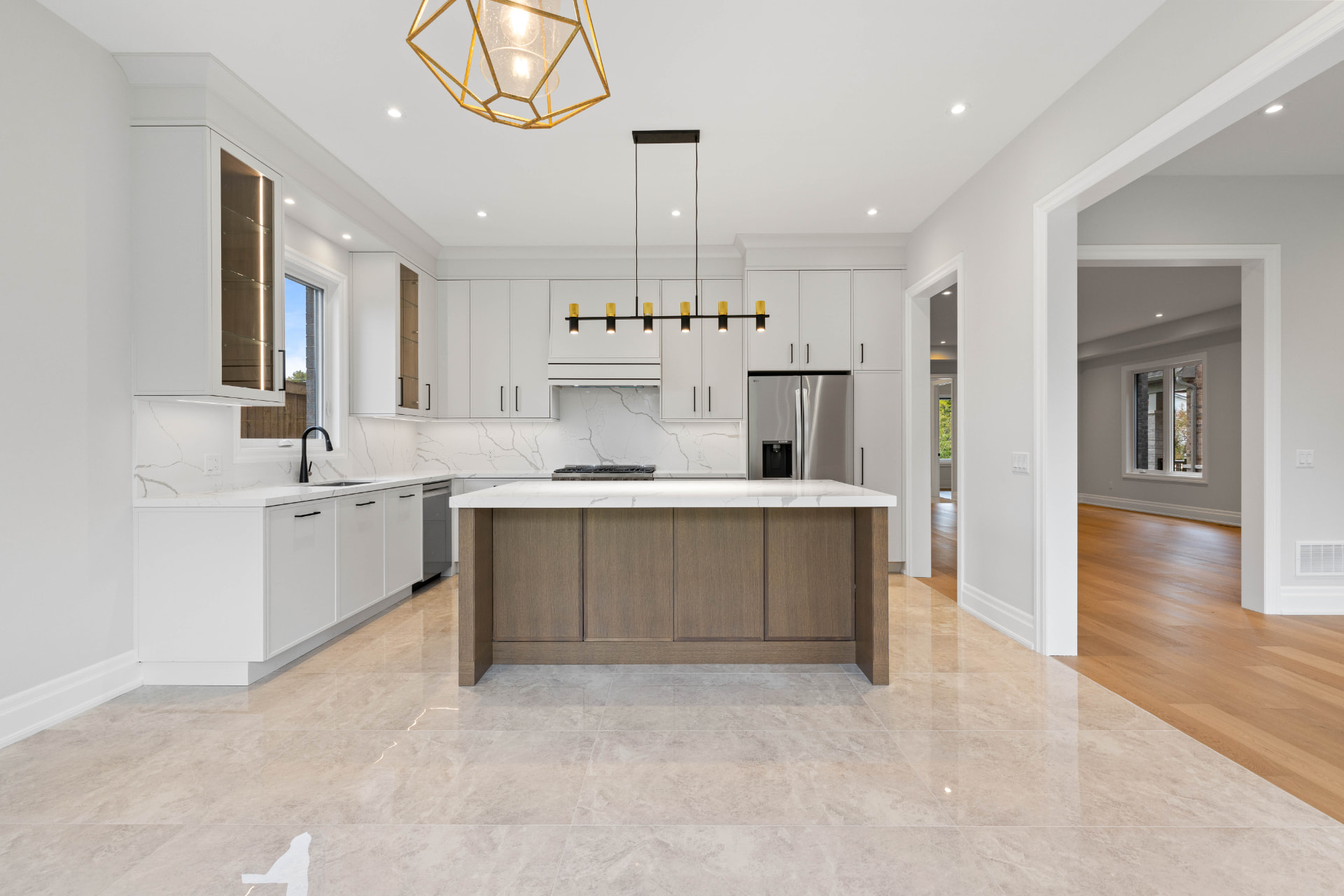 Kitchen with white cabinetry, quartz island and marble-look tile floor