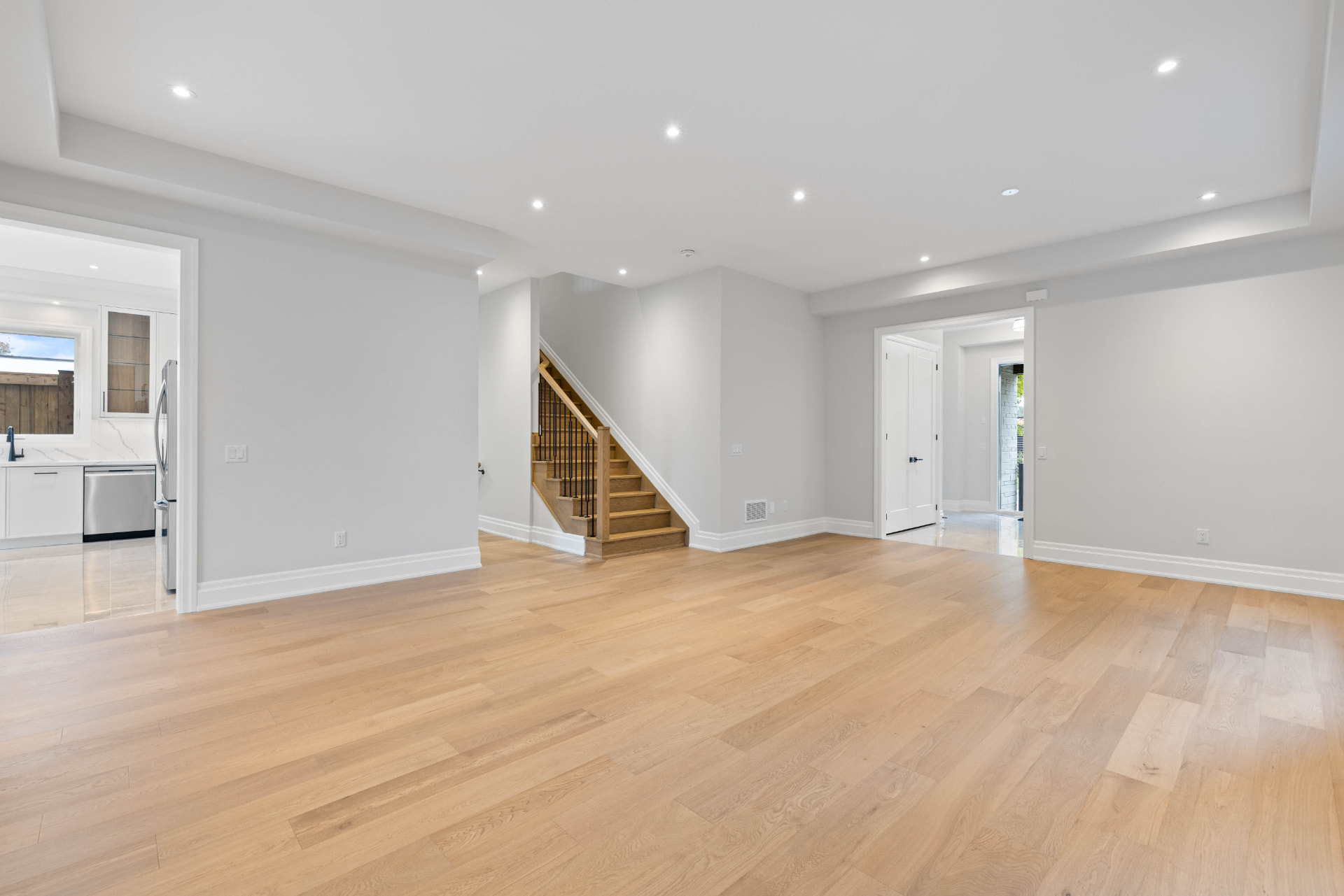 Open-concept main floor with wide-plank oak floors and oak staircase